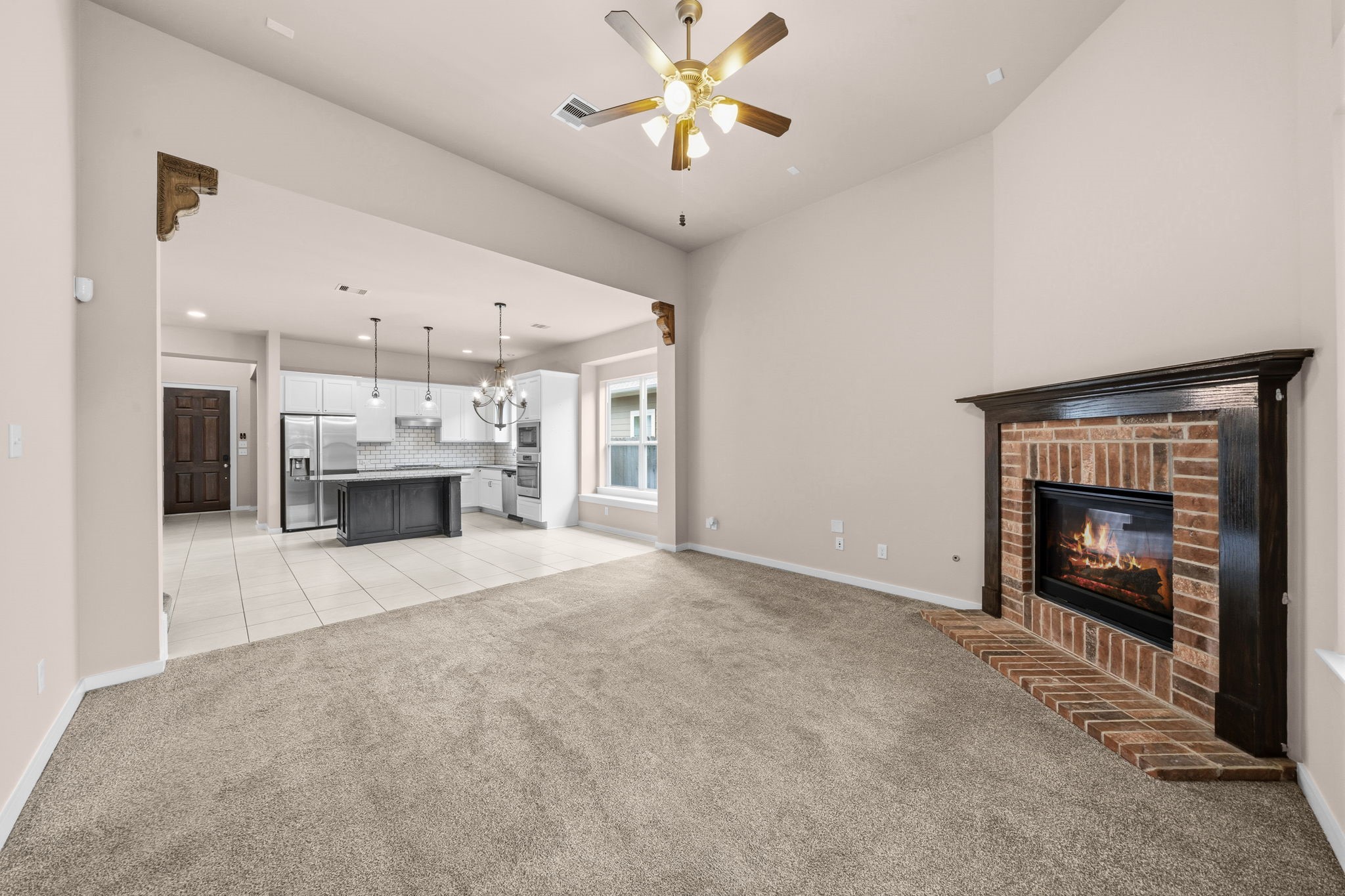 17019 Seminole Ridge Drive Cypress, TX 77433 - Photo 17 of 48 Opposite view of this open-concept living area with soaring ceilings and a cozy brick fireplace, seamlessly flowing into the updated kitchen. Spacious layout ideal for everyday living and entertaining.