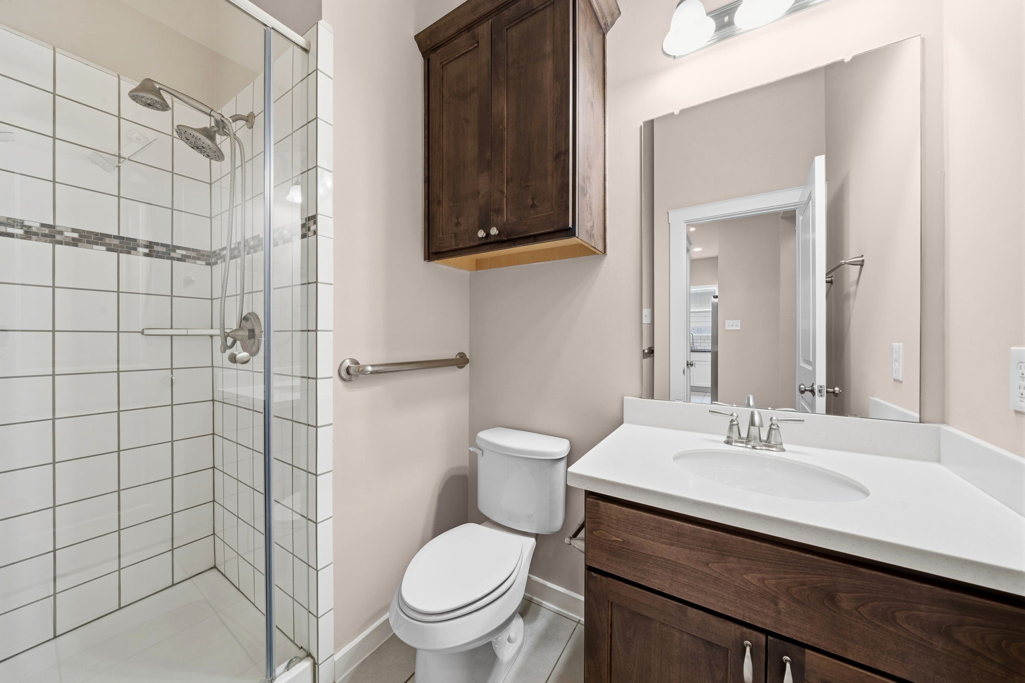 17019 Seminole Ridge Drive Cypress, TX 77433 - Photo 24 of 48 Off the downstairs secondary bedroom is this bath featuring a glass-enclosed shower with tile surround and decorative accent band. Wood cabinetry and updated fixtures add warmth and style to this functional space.