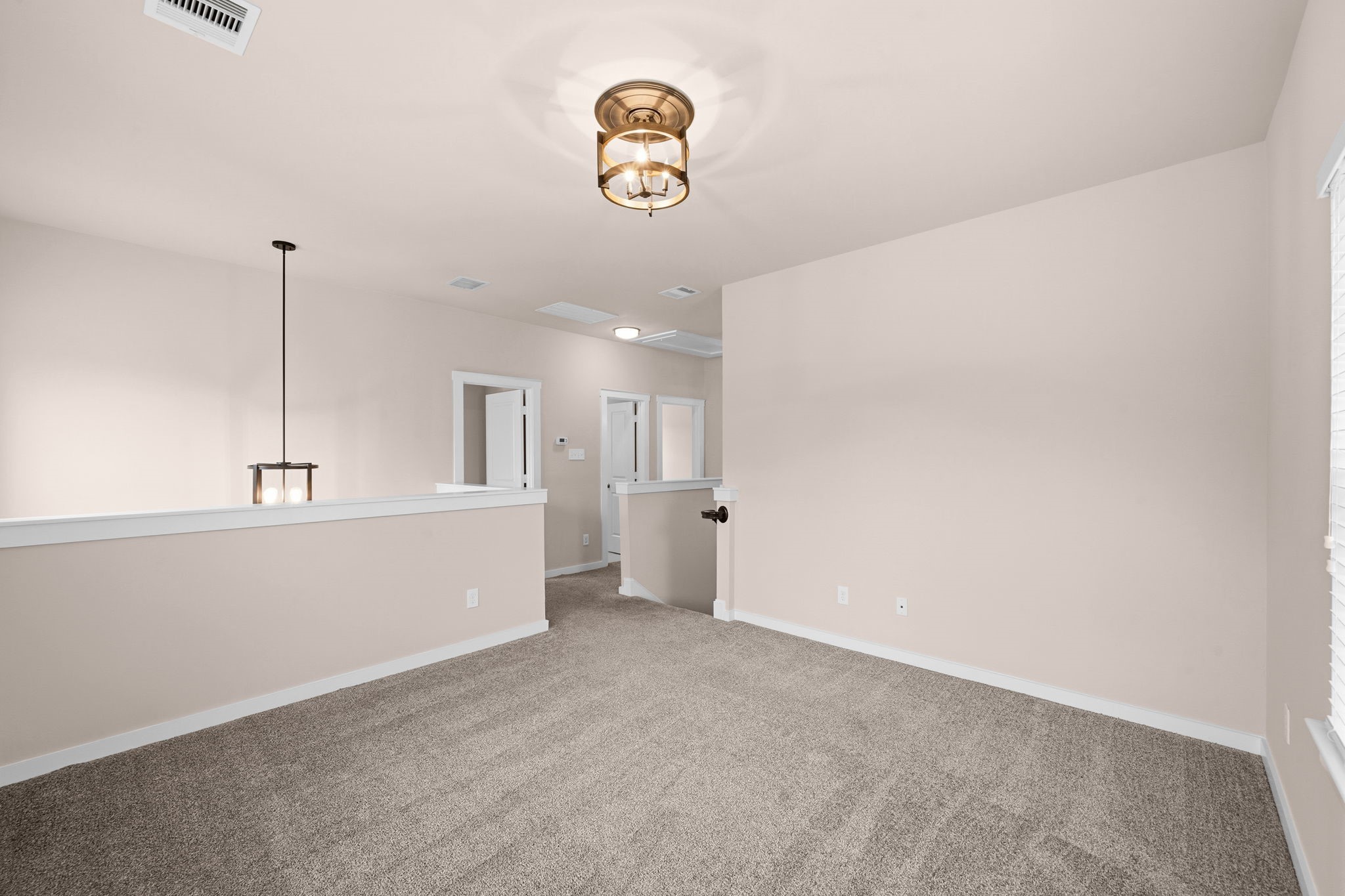 17019 Seminole Ridge Drive Cypress, TX 77433 - Photo 25 of 48 Spacious upstairs game room with plush carpet and stylish lighting, offering a versatile space for entertainment, a media room, or a play area. Open railing adds architectural interest and an airy feel.