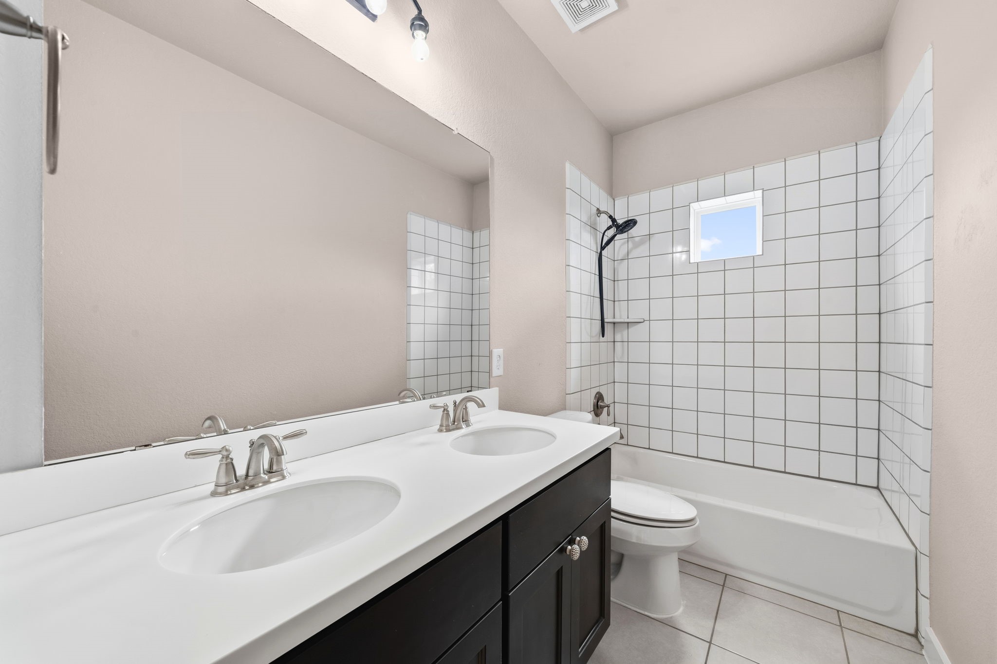 17019 Seminole Ridge Drive Cypress, TX 77433 - Photo 29 of 48 Spacious upstairs secondary bath featuring dual sinks with a sleek vanity and a tub/shower combo with classic tile surround. Bright, functional layout ideal for family or guests.