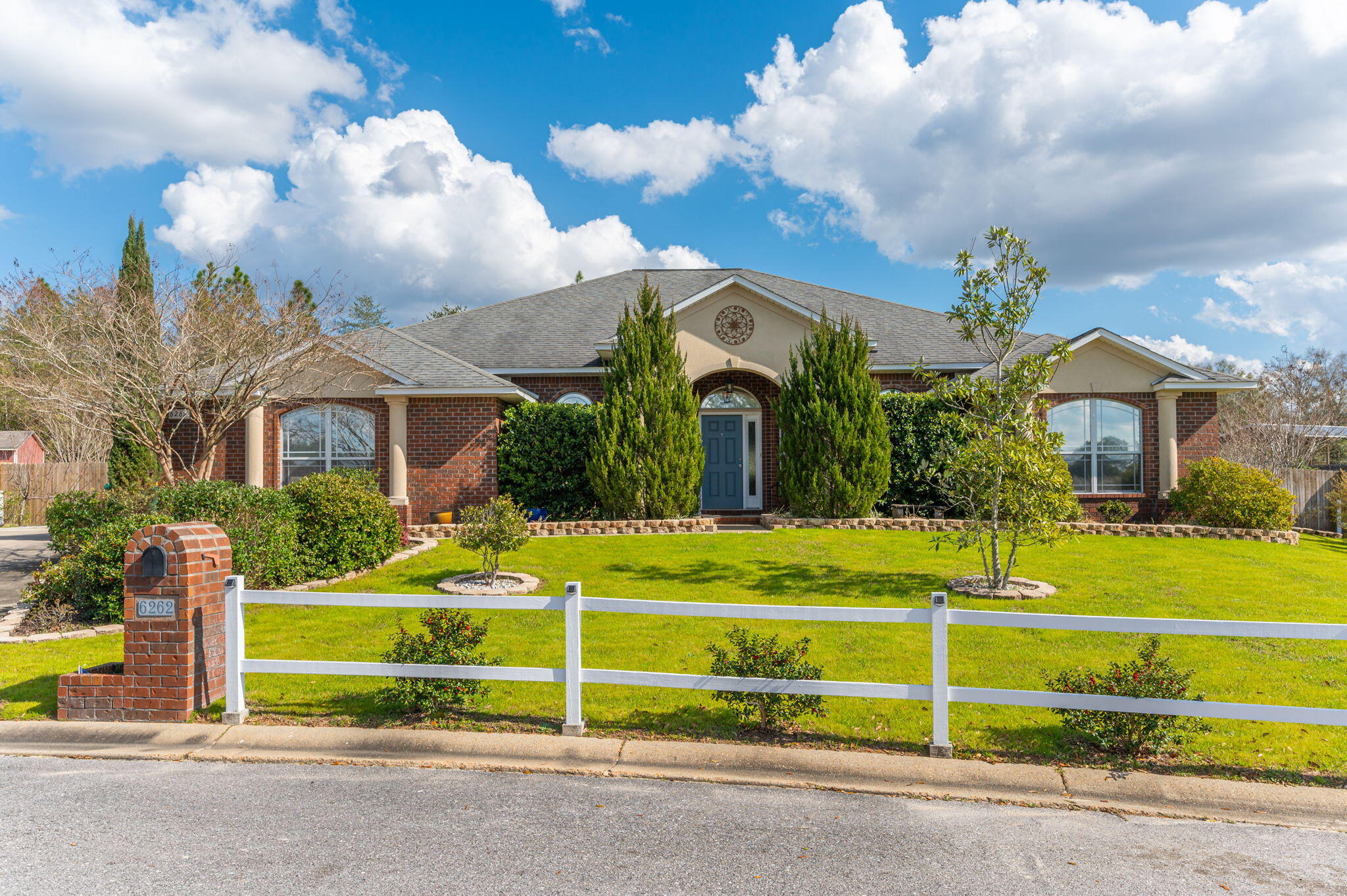 a view of a house with a big yard and potted plants