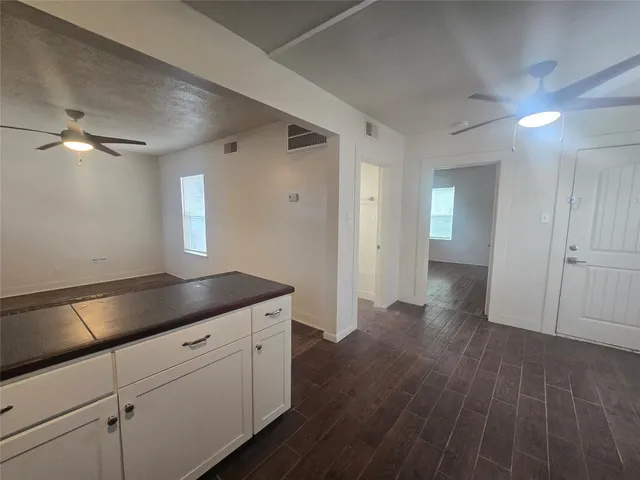 a kitchen with cabinets and wooden floor