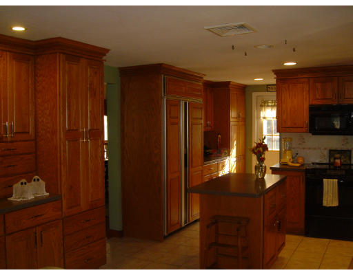 294 Brookfield Road Sturbridge, MA 01518 - Photo 16 of 28 a kitchen with stainless steel appliances kitchen island granite countertop furniture a refrigerator and wooden cabinets