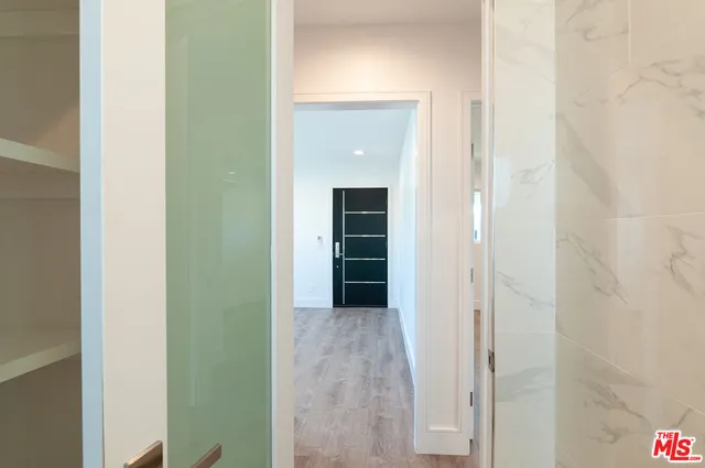 a view of a hallway with wooden shelves
