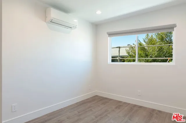 a view of a small space with wooden floor and a window