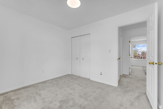 1147 West State Road Lehi, UT 84043 - Photo 22 of 31 Carpeted room featuring a ceiling-mounted light fixture, white walls, and bi-fold closet doors with brass hardware