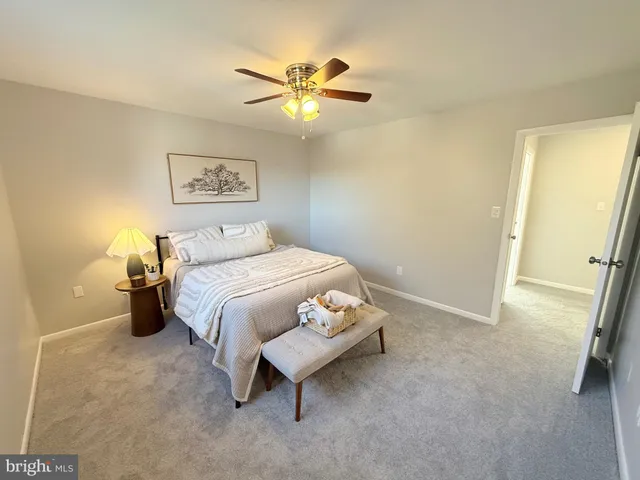 a bedroom with a bed and a ceiling fan