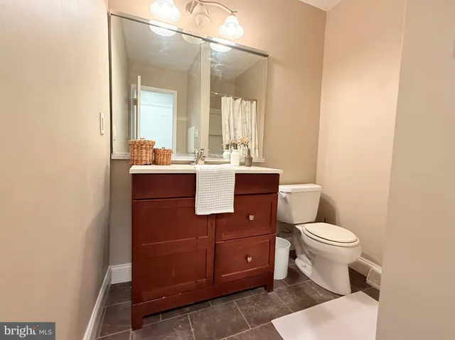 a bathroom with a toilet sink and mirror