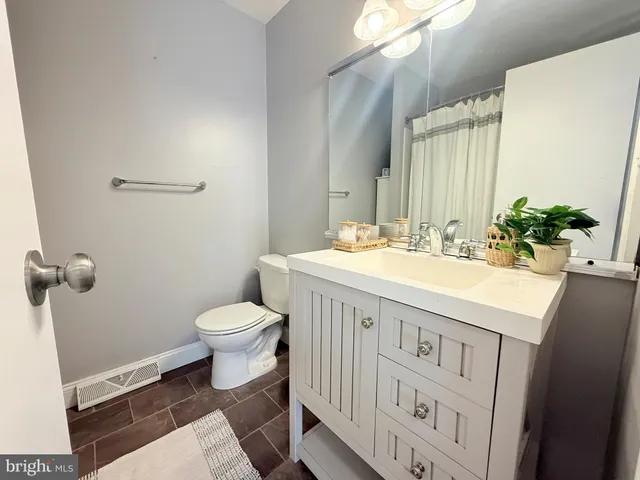 a bathroom with a sink a toilet and mirror