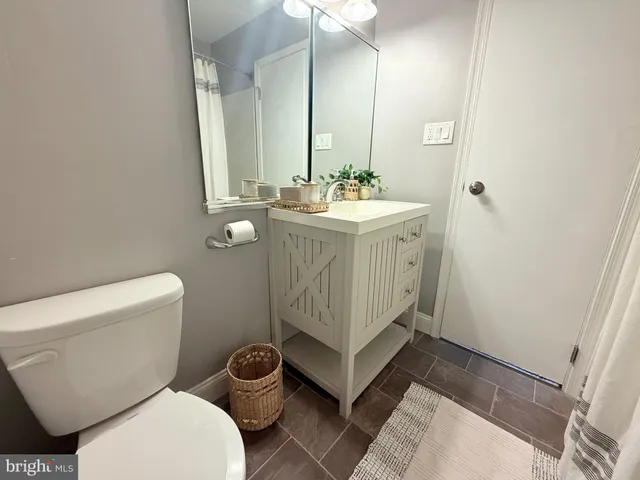 a bathroom with a sink mirror vanity and toilet
