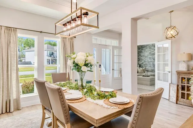 a view of a dining room with furniture large windows and wooden floor