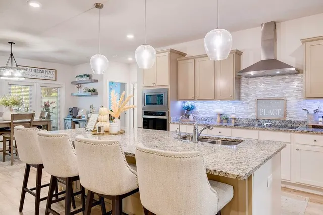 a kitchen with cabinets a sink stove and chairs