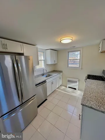 a kitchen with stainless steel appliances granite countertop a refrigerator sink and stove