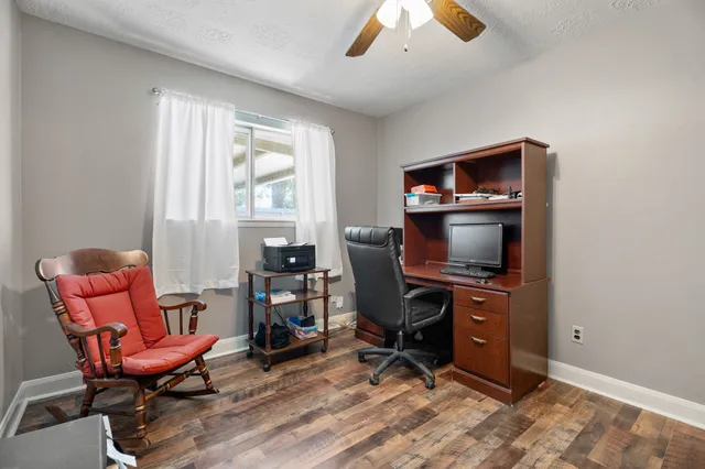 a view of a workspace with furniture and a window