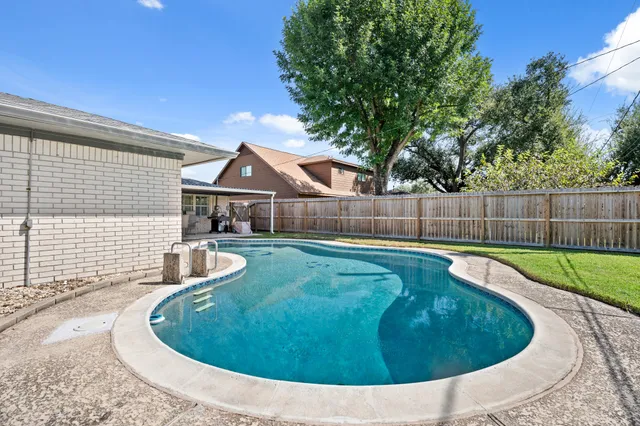 a view of a backyard with swimming pool