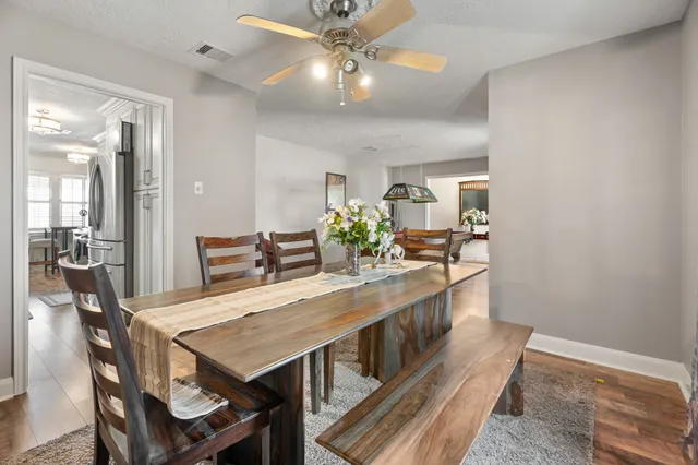 a view of a dining room with furniture a chandelier and wooden floor
