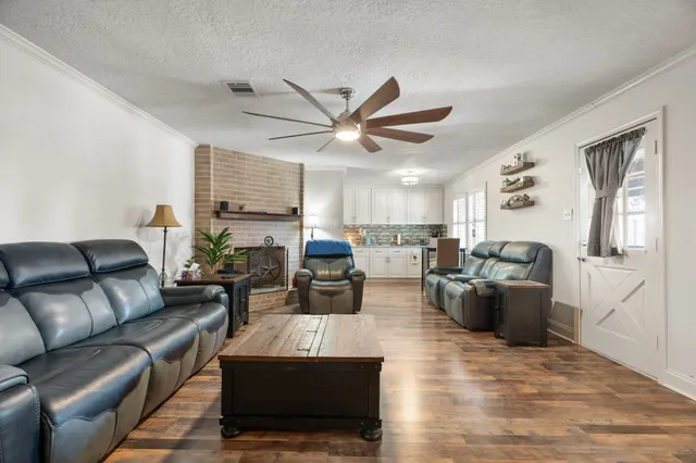 a living room with furniture kitchen view and a window