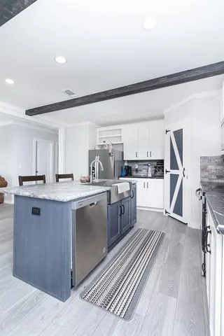 a large kitchen with kitchen island a sink stainless steel appliances and cabinets