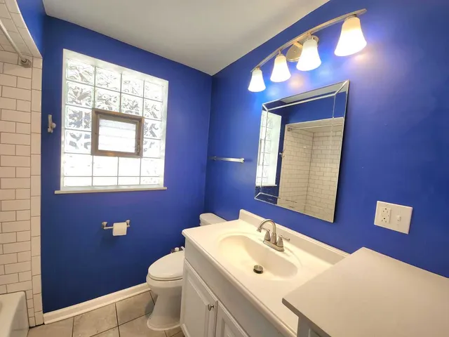 a bathroom with a toilet sink vanity and mirror