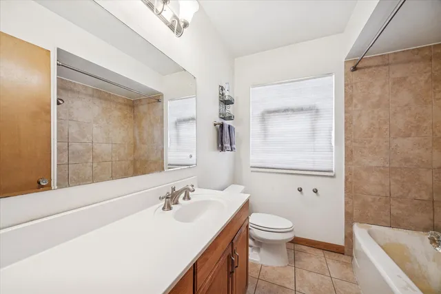 a bathroom with a granite countertop sink a toilet and a bathtub