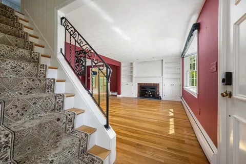 a view of a livingroom with wooden floor and staircase