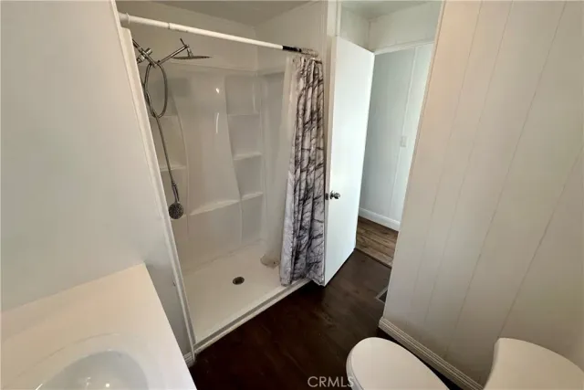 a bathroom with a glass door shower and toilet