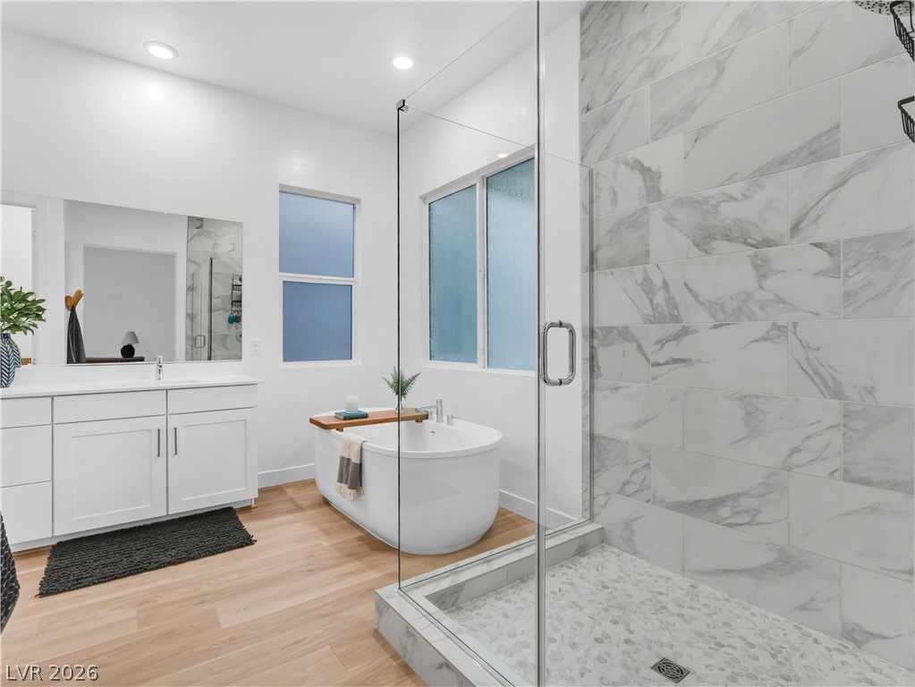 153 Montevallo Bnd Street Henderson, NV 89015 - Photo 29 of 65 Full bath featuring a marble finish shower, light wood finished floors, vanity, a soaking tub, and recessed lighting