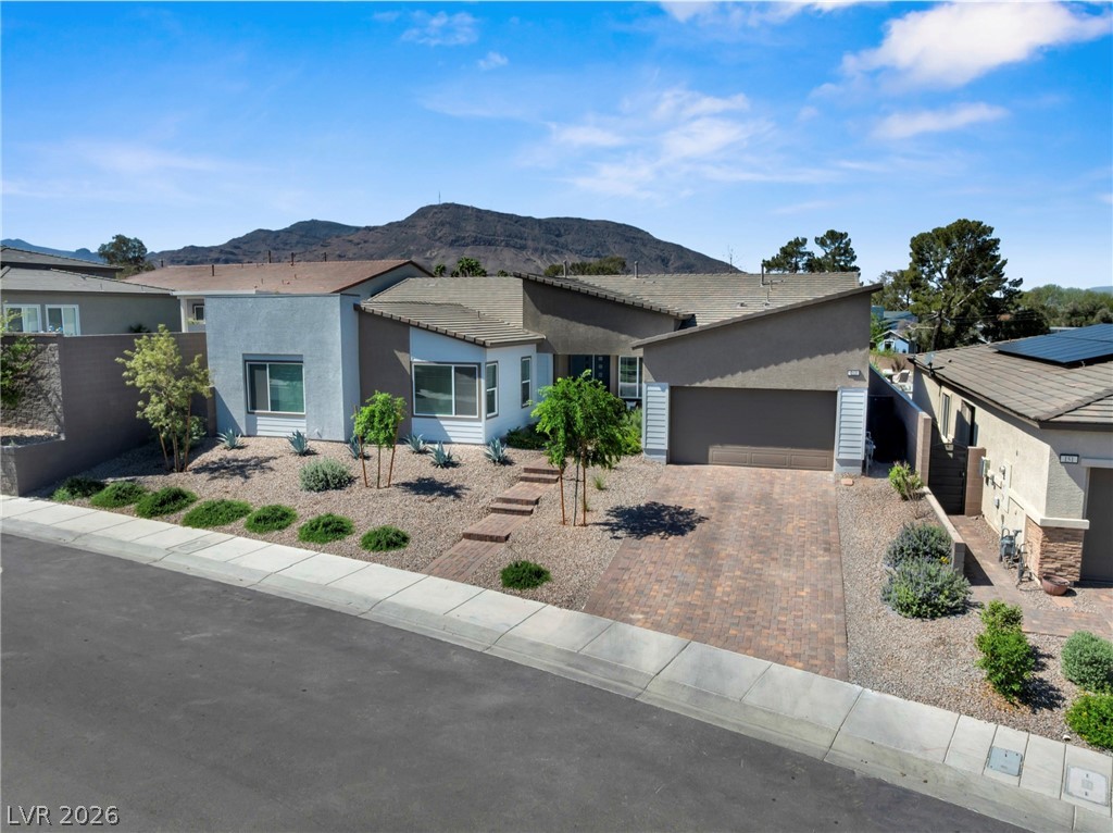 153 Montevallo Bnd Street Henderson, NV 89015 - Photo 7 of 65 View of front of house featuring a mountain view, stucco siding, a garage, and decorative driveway