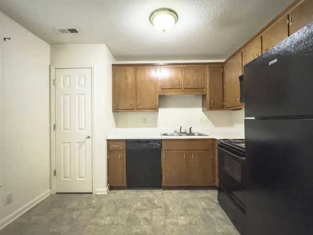 a kitchen with granite countertop a refrigerator and a sink