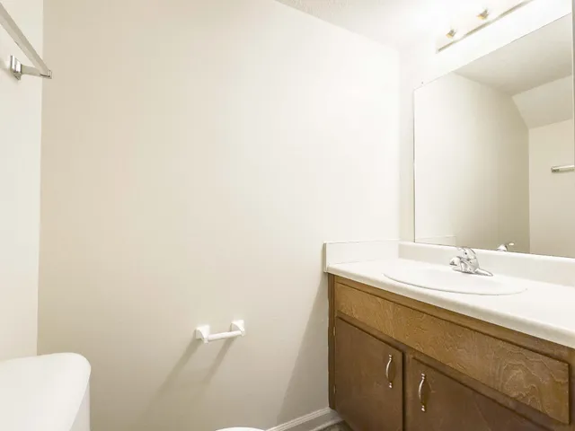 a bathroom with a sink a toilet and a mirror