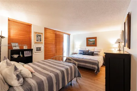 a bedroom with a bed and a dresser next to a window