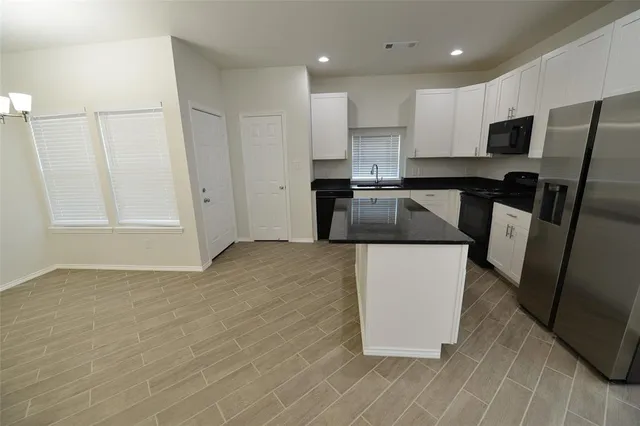 a kitchen with stainless steel appliances granite countertop a refrigerator and a stove top oven