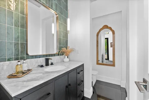 a bathroom with a toilet sink and mirror
