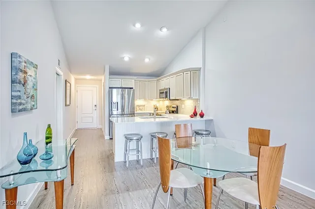 a living room with furniture a flat screen tv and kitchen view