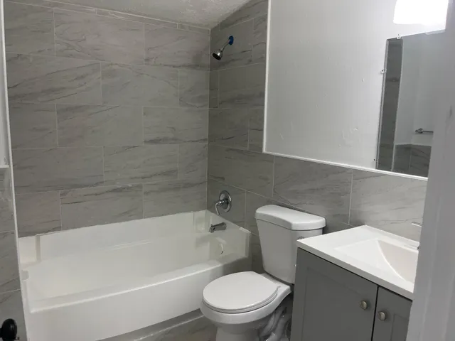 a white toilet and tub sitting next to a bathroom sink