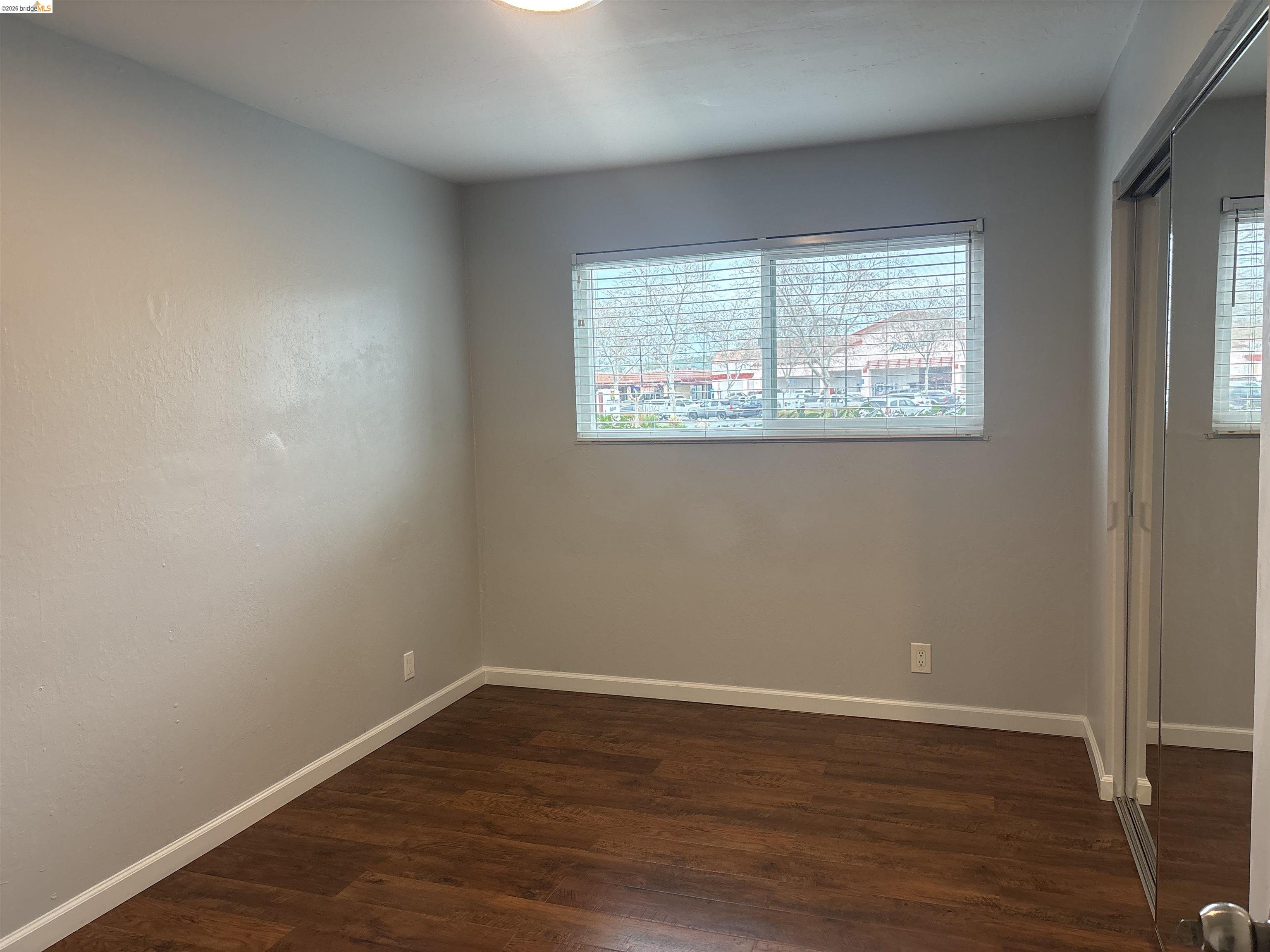 4462 Clayton Road, Unit A Concord, CA 94521 - Photo 5 of 11 an empty room with wooden floor and windows