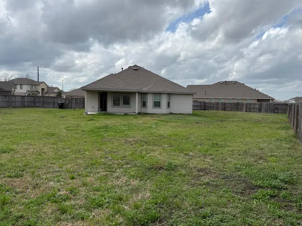 a white house with a big yard and large trees