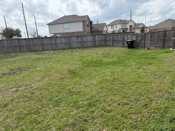 a view of a house with a yard and wooden fence