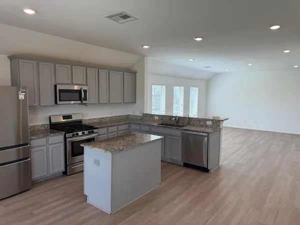 a kitchen with a sink and steel appliances