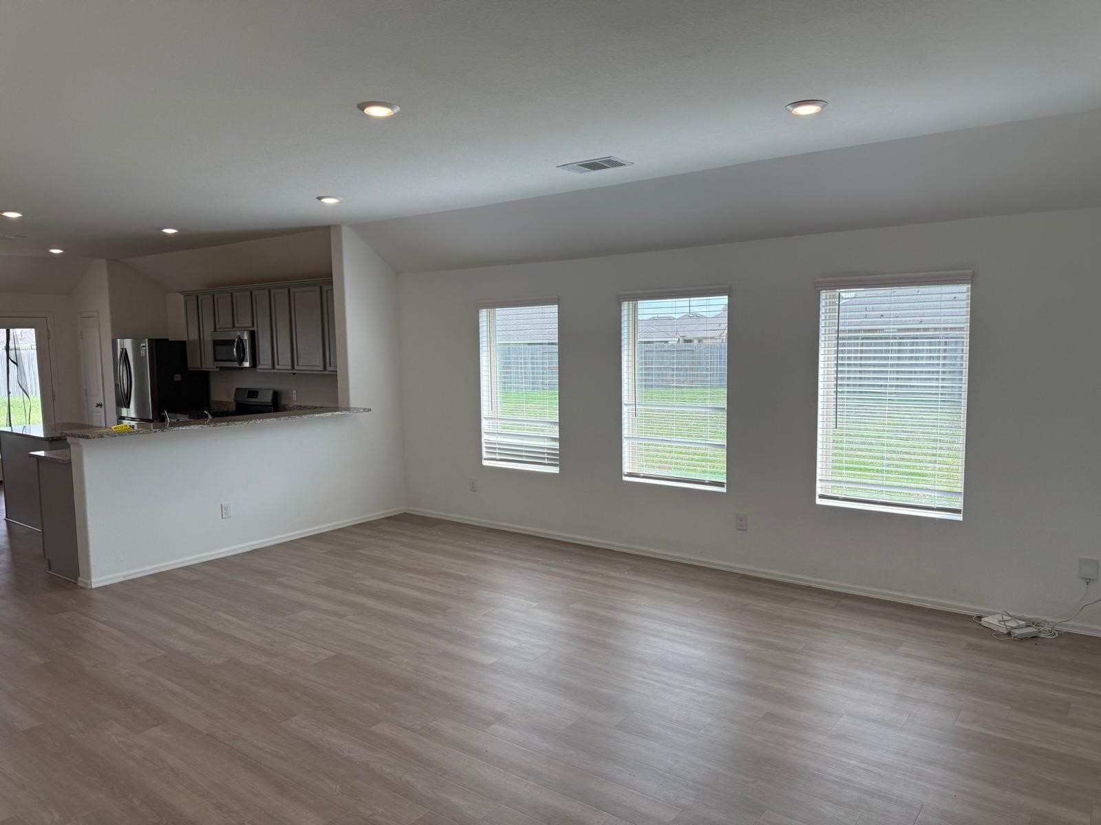 5335 Winding Strm Drive Rosenberg, TX 77469 - Photo 6 of 26 an empty room with wooden floor and windows