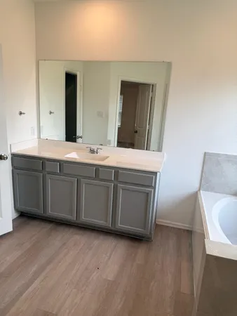 a spacious bathroom with a double vanity sink and mirror