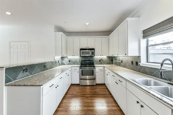 a kitchen with granite countertop a sink and steel appliances