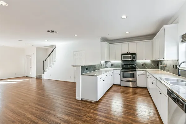 a kitchen with stainless steel appliances a refrigerator sink and microwave