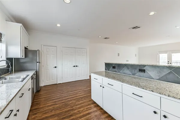 a kitchen with granite countertop a sink and cabinets