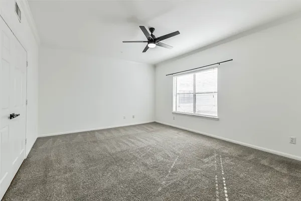 an empty room with windows and ceiling fan view