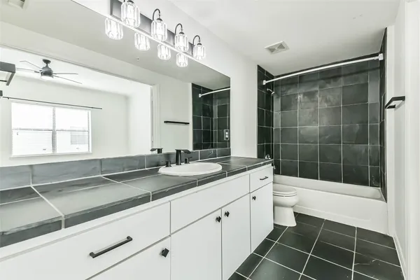 a bathroom with a sink vanity granite and toilet
