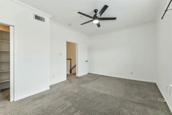 an empty room with a ceiling fan and window