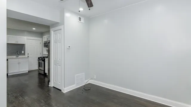 a view of a kitchen with white cabinets and wooden floor