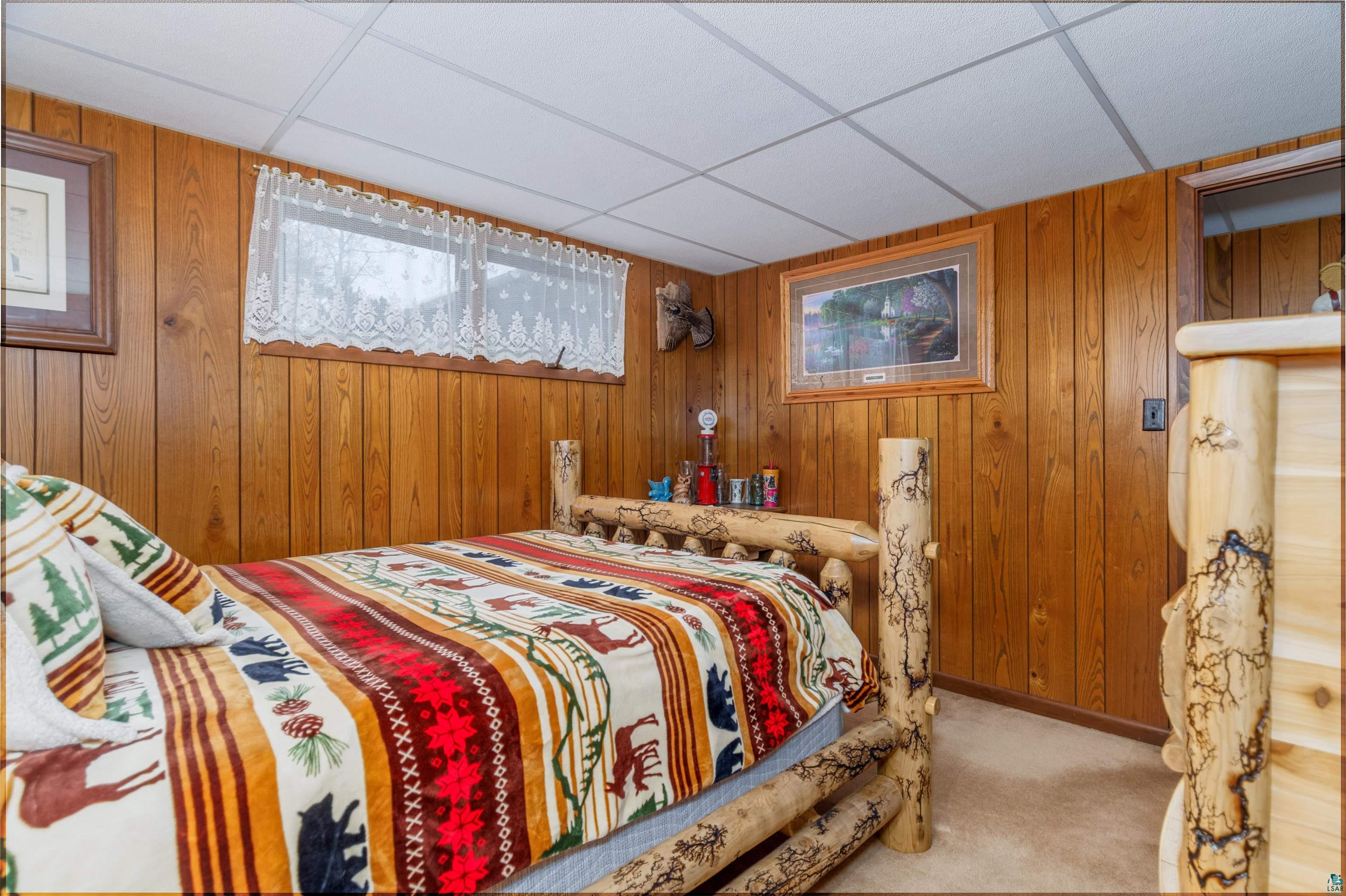 2641 Priest Point Road Ely, MN 55731 - Photo 19 of 38 Bedroom with carpet flooring, wooden walls, and a drop ceiling