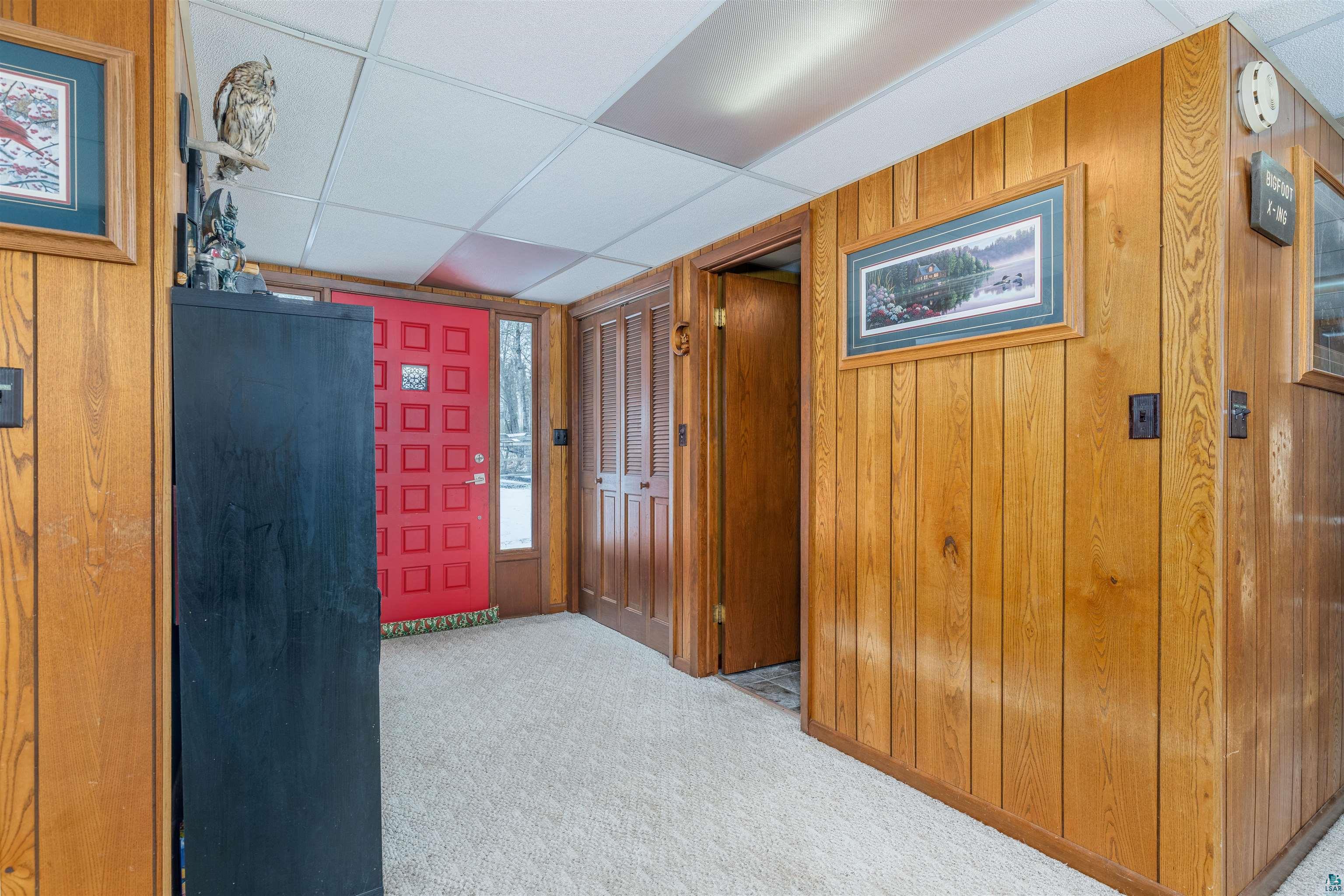 2641 Priest Point Road Ely, MN 55731 - Photo 27 of 38 Foyer with wooden walls, a drop ceiling, and light carpet